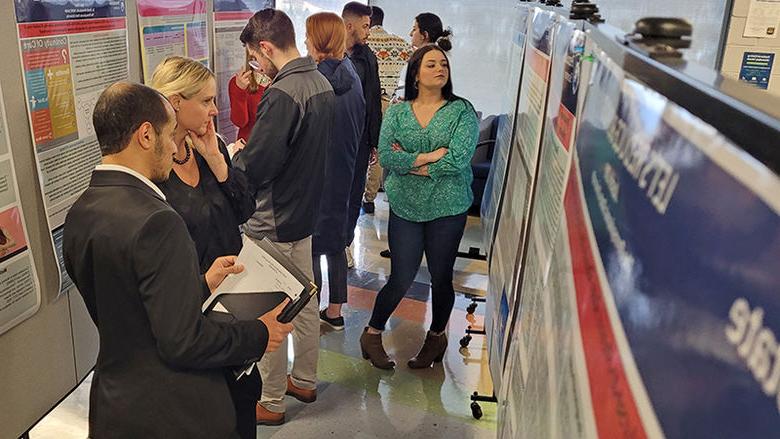 Attendees check out some of the poster displays at Scranton's research fair